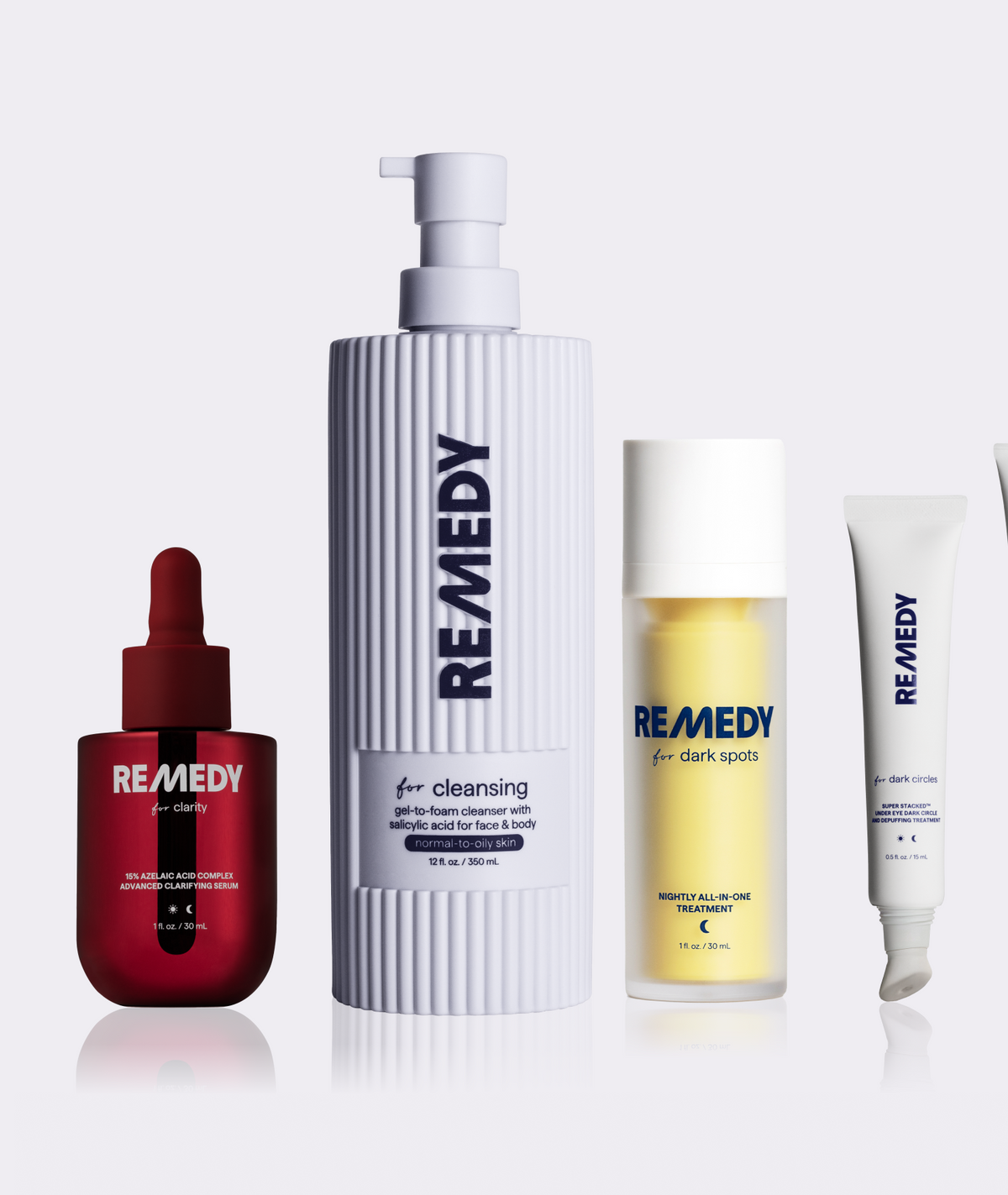Four REMEDY skincare bottles and tubes arranged on a light gray studio background: a deep red dropper bottle, a tall white ribbed cleansing bottle with a pump, a frosted bottle with pale yellow liquid, and a white tube.